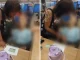 Mulher tenta ajustar a cabeça de um corpo sentado em uma cadeira de rodas diante do balcão de banco em Bangu.