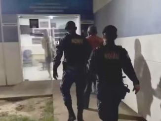 magem mostra um homem sendo escoltado por dois guardas civis até a delegacia de Luís Eduardo Magalhães, na Bahia, após ser preso sob suspeita de sequestro e abuso de criança de 9 anos