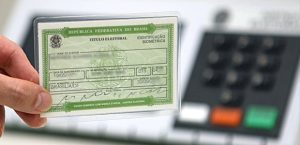 Imagem mostra título eleitoral com uma urna eletrônica ao fundo, usada para eleição municipal de 6 de outubro.