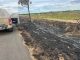 Veículo da Polícia Militar estacionado ao lado de uma área queimada ao longo da BR-242, em Luís Eduardo Magalhães, na Bahia, indicando um foco de incêndios criminosos