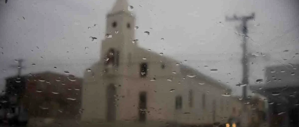 Alerta amarelo: Formosa do Rio Preto e mais 13 cidades têm previsão de chuvas intensas; Igreja de Formosa do Rio Preto vista através de um vidro com gotas de chuva, em um dia nublado e chuvoso.